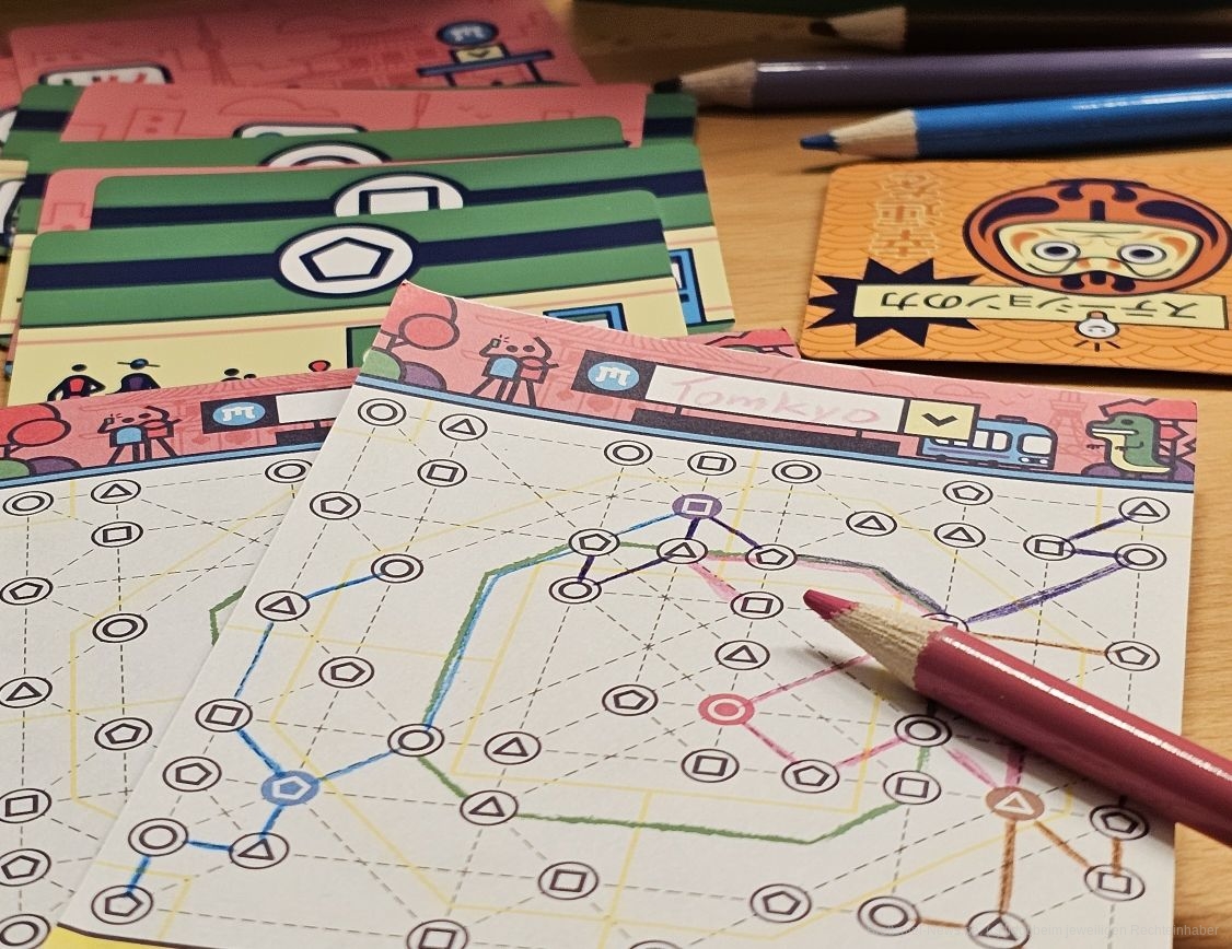 Wir reisen nach Tokyo und werden im Wettstreit gegeneinander mit einem Flip and Write - Mechanismus die U-Bahn-Pläne der Stadt neu zeichnen, um den touristischen Herausforderungen von morgen zu begegnen.